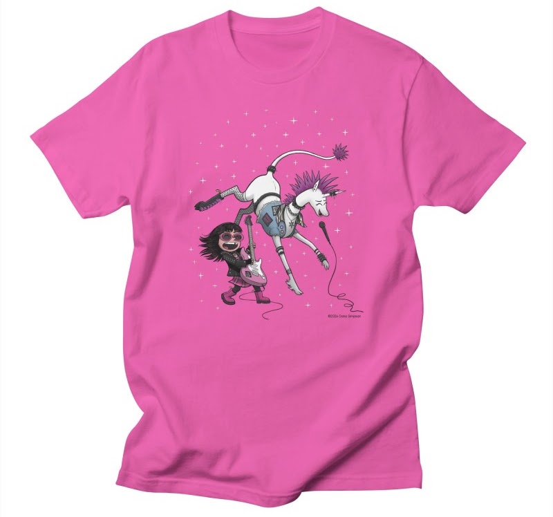 Pink tee shirt with an image of Phoebe (a girl) and Marigold (a unicorn), dressed as punks. Phoebe is playing a guitar and Marigold is singing into a microphone.